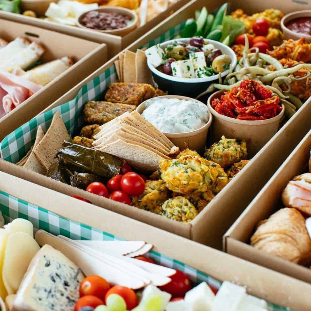 Assorted gourmet food platter with dips, vegetables, and finger foods for entertaining.